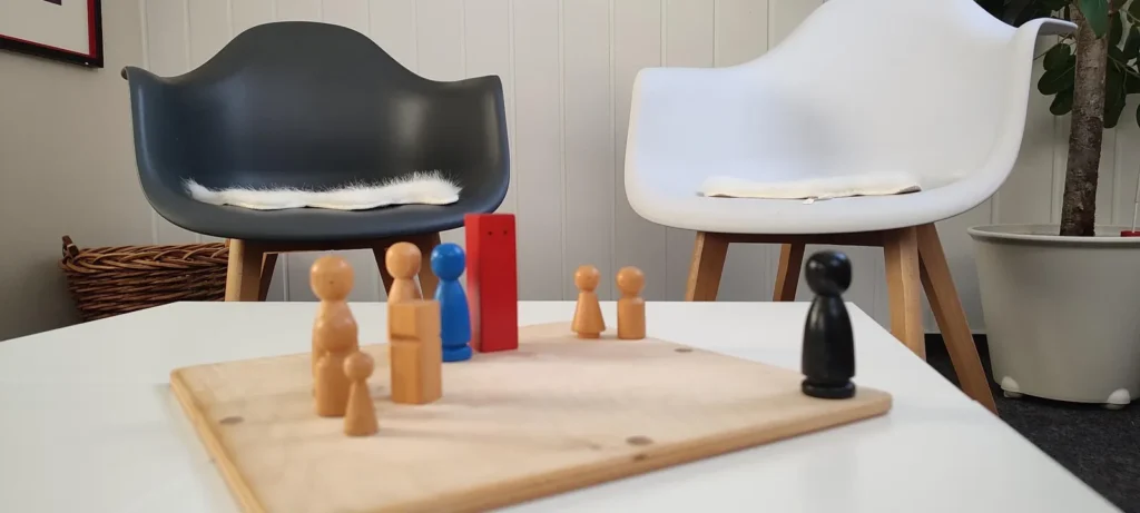 Holzfiguren stehen auf einem Familienbrett.