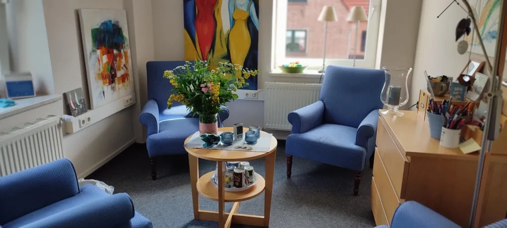 Therapieraum mit blauen Sesseln, Blumen auf dem Tisch.
